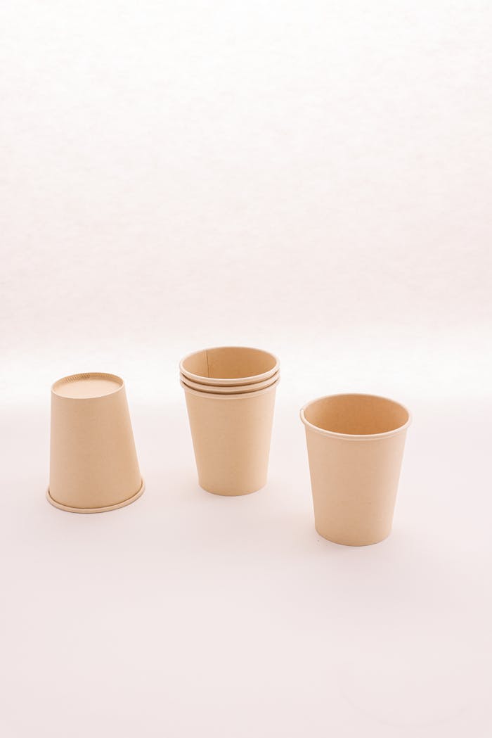 Set of biodegradable paper cups on a neutral background, highlighting eco-friendly design.